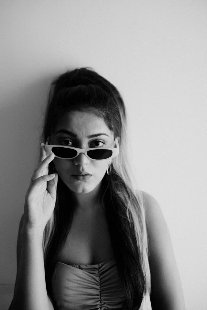 Mujer con gafas de sol blancas, retrato en blanco y negro